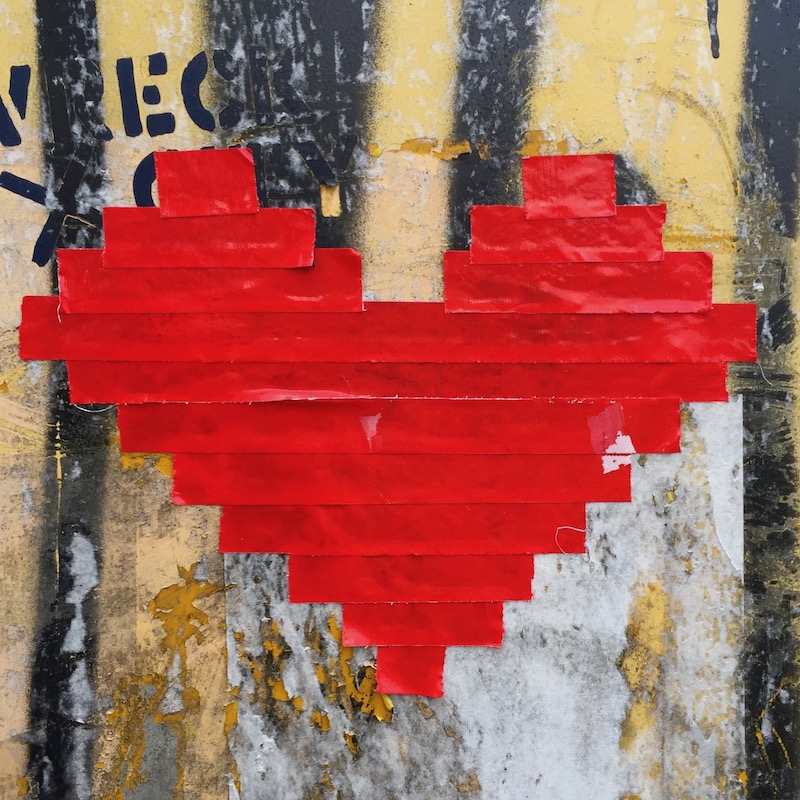 heart shape made from red duct tape on rough wall
